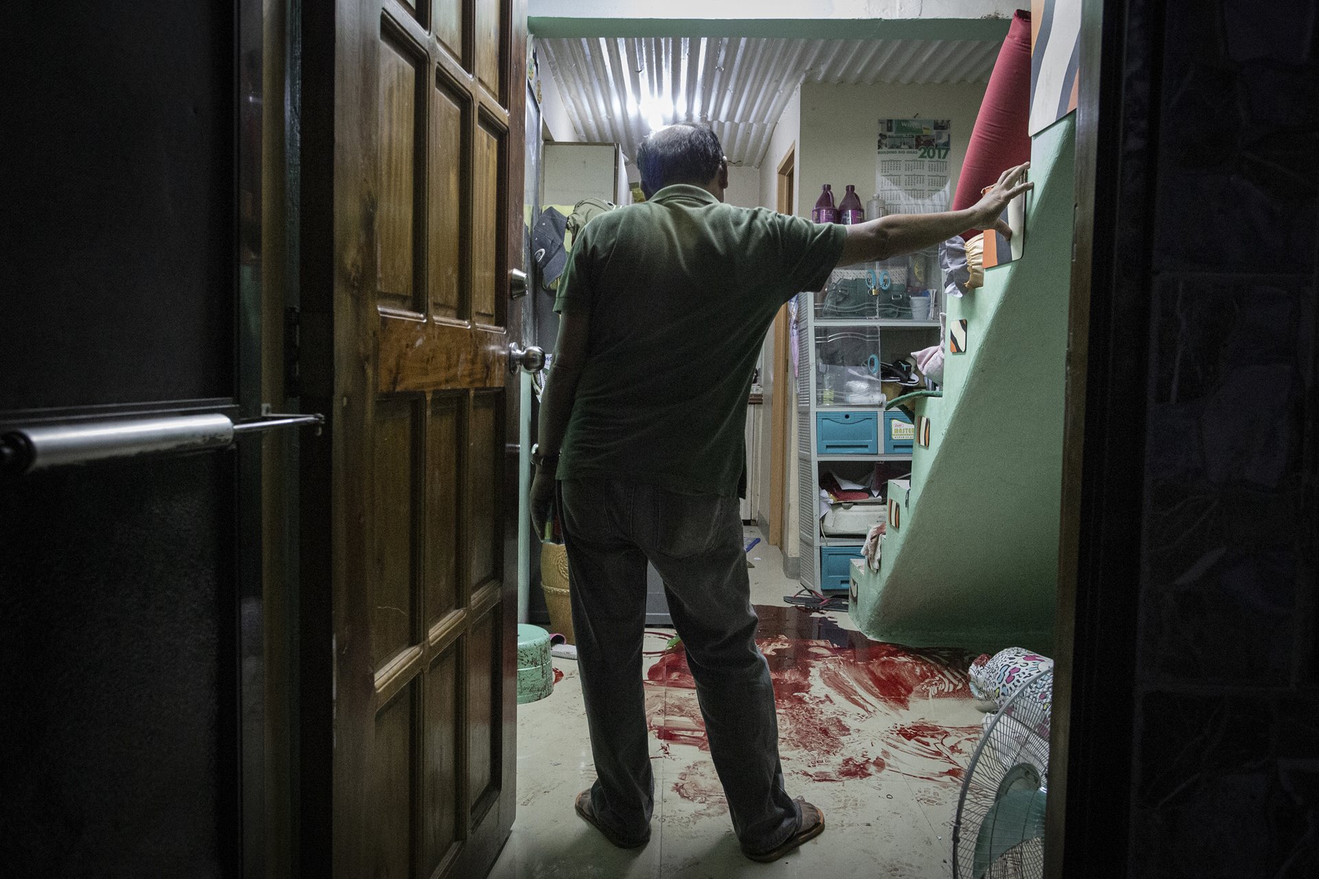 Marianito Libo-on surveys the room where his son Jomar, who worked as an electrician, was killed moments before, in Quezon City, the Philippines. Five masked men barged into Jomar Libo-on&rsquo;s home as he was watching TV, and shot him in front of his wife, son and daughters.