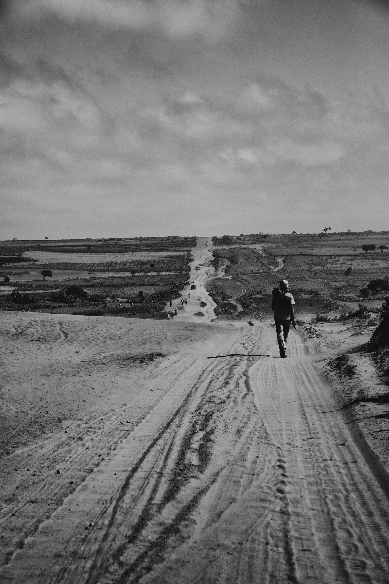 A man walks along the national road connecting Amboasary Sud and Ambovombe, in southern Madagascar. The region is isolated, and poor infrastructure hinders economic development. Economic deprivation and a food crisis in the region are thought to be factors in turning young men to cattle theft. The isolation and inadequate infrastructure are obstacles to controlling the crime.
