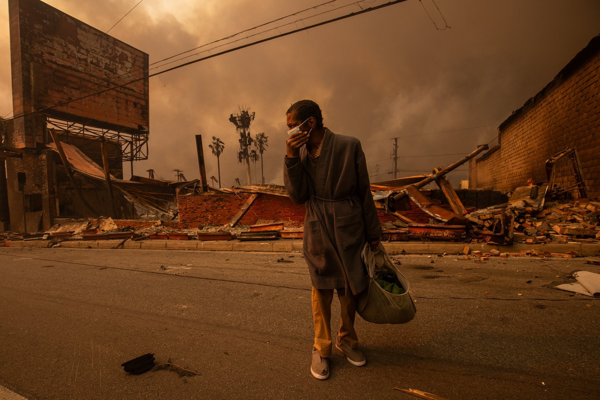 <p>A man walks past a business ruined by fire. The Eaton Fire heavily impacted working-class neighborhoods, where many underinsured homeowners now face gentrification and displacement. Altadena, California, United States</p>
