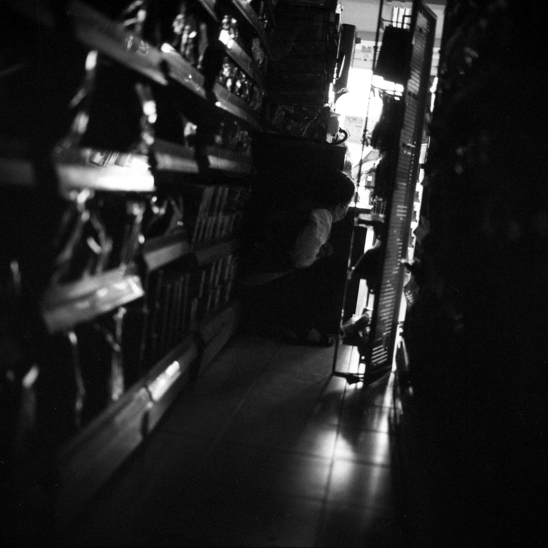 A member of staff at a convenience store hides behind a shelf, as security forces raid residential buildings to arrest protesters in Yangon, Myanmar. According to the UN, at least 18 people were killed in the protests that day.