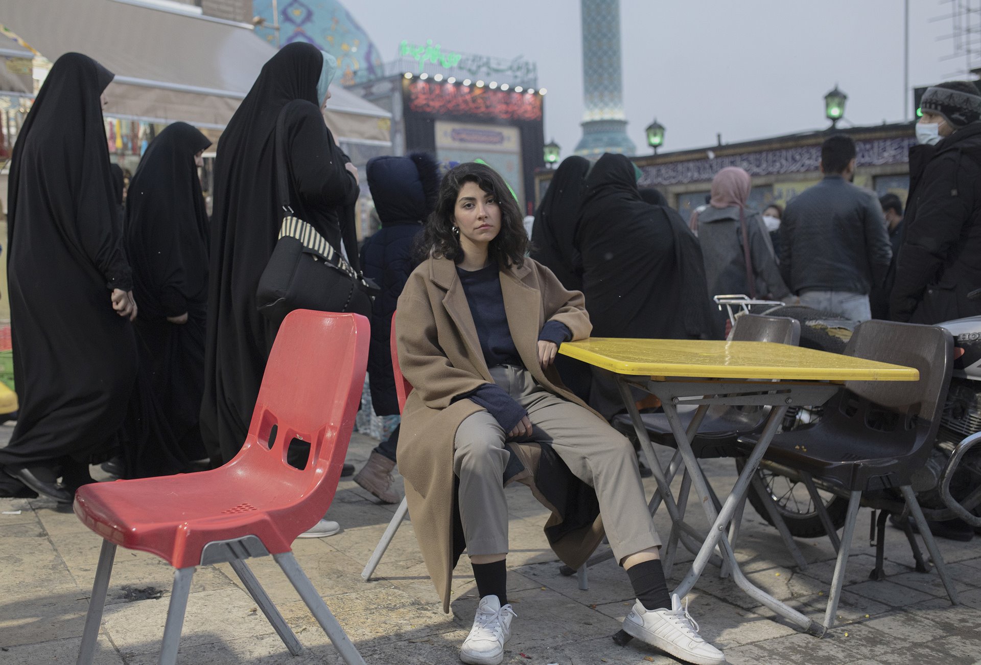 <p>An Iranian woman sits on a chair in front of a busy square in Tehran, defying the mandatory hijab law. &ldquo;A few days after Mahsa&rsquo;s death, I was walking past Keshavarz Boulevard when I saw a massive crowd of men and women, young and old, chanting a slogan that I&rsquo;ve never heard before: &lsquo;Woman, Life, Freedom&rsquo;. It enlightened me, it was moving,&rdquo; she said.</p>
