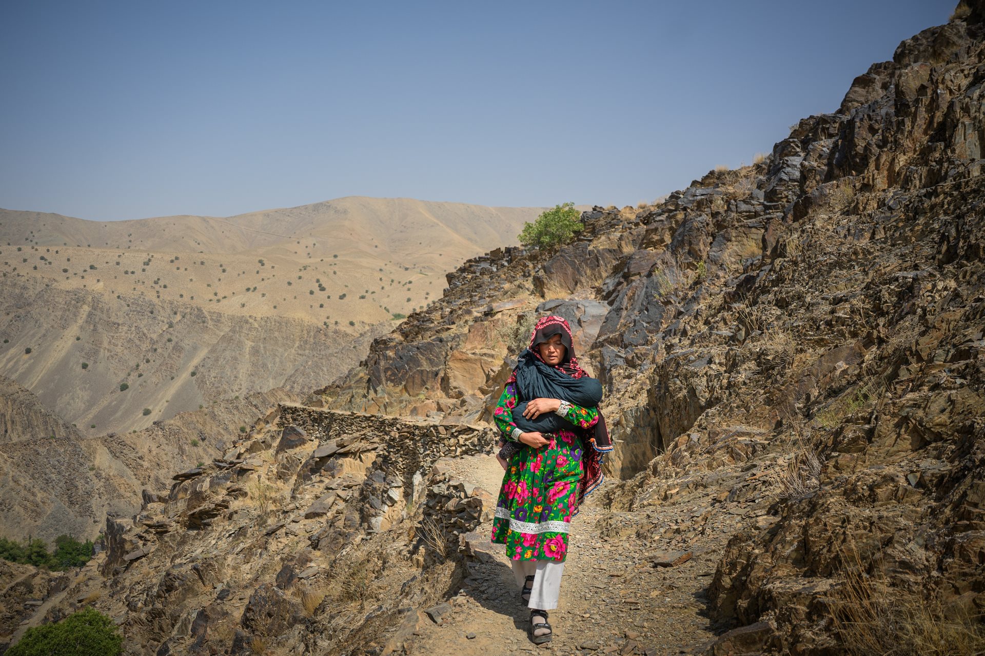 Zahira walks back from visiting a pregnant woman who is worried she might have to give birth without a midwife. Dahan-e-Tokhomak, Miramor district,&nbsp;Daikundi province, Afghanistan.