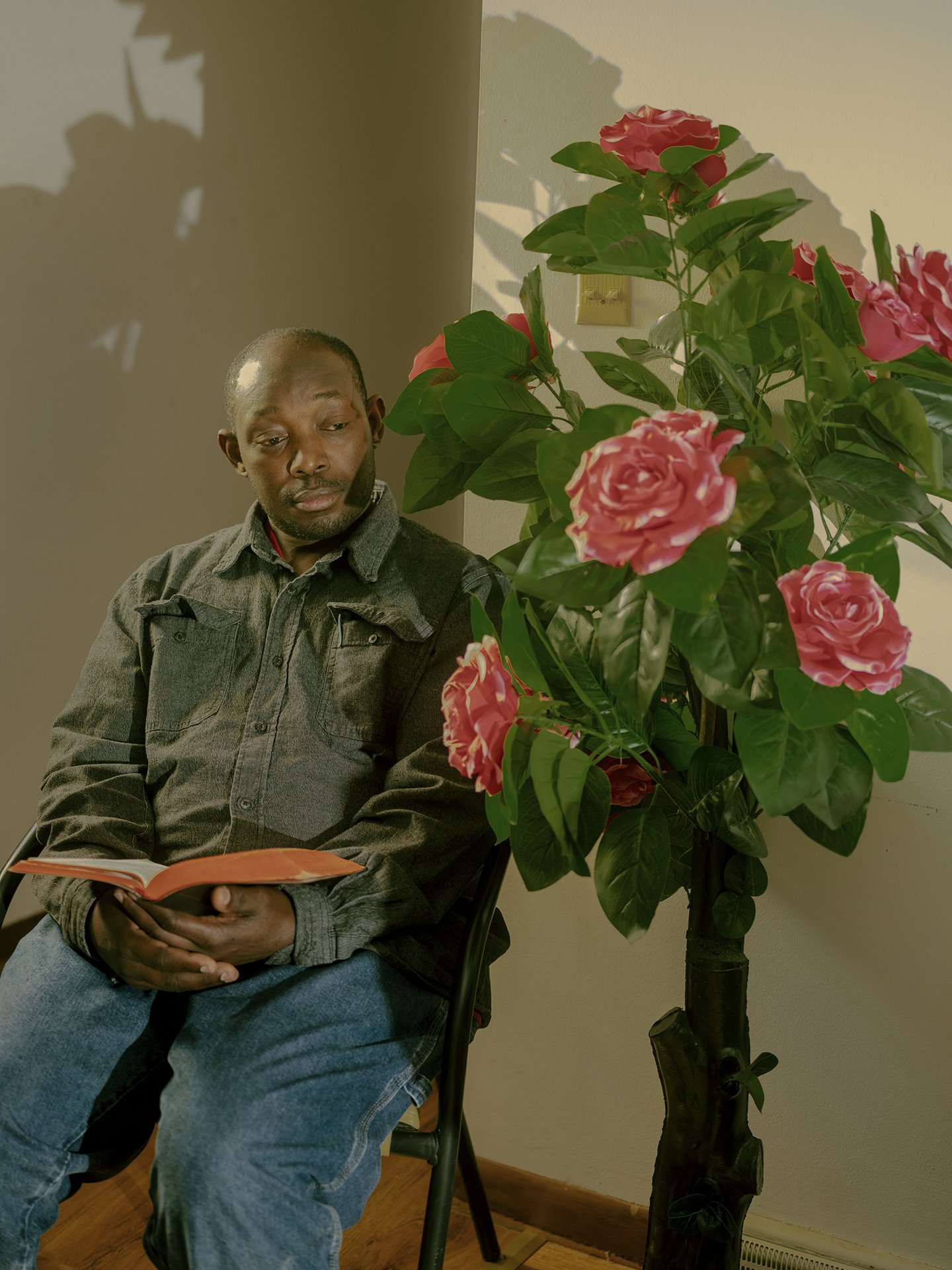 Michael Ndagijimana, a pastor in a Burundian church in Omaha, Nebraska, USA, sits at home. He works at a meatpacking plant in Omaha.