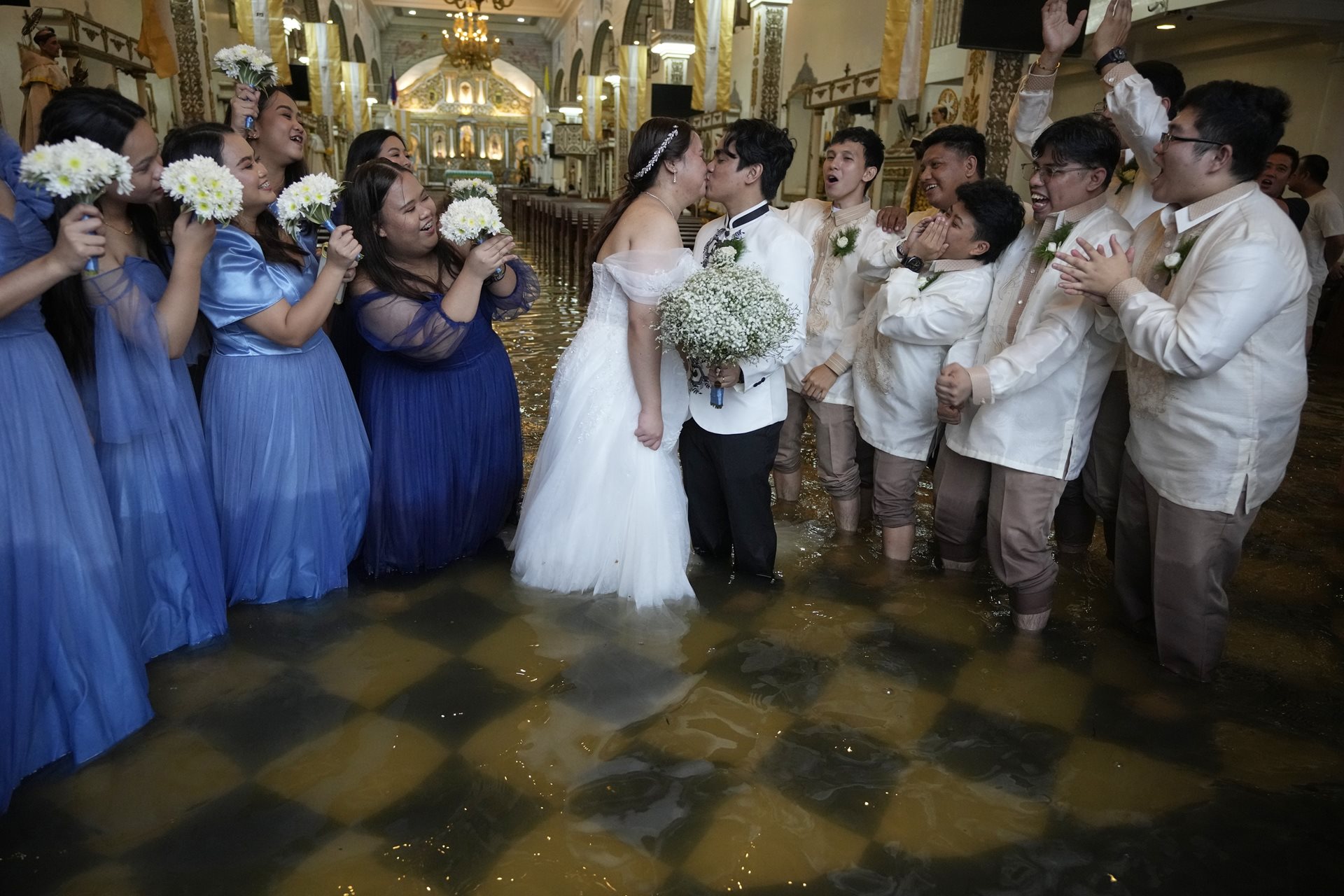 The newlyweds share a kiss as guests cheer. The couple have been together for ten years. According to Jade Rick Verdillo, the groom, &ldquo;This is just one of the struggles that we&rsquo;ve overcome.&rdquo; Malolos, Bulacan province, Philippines.