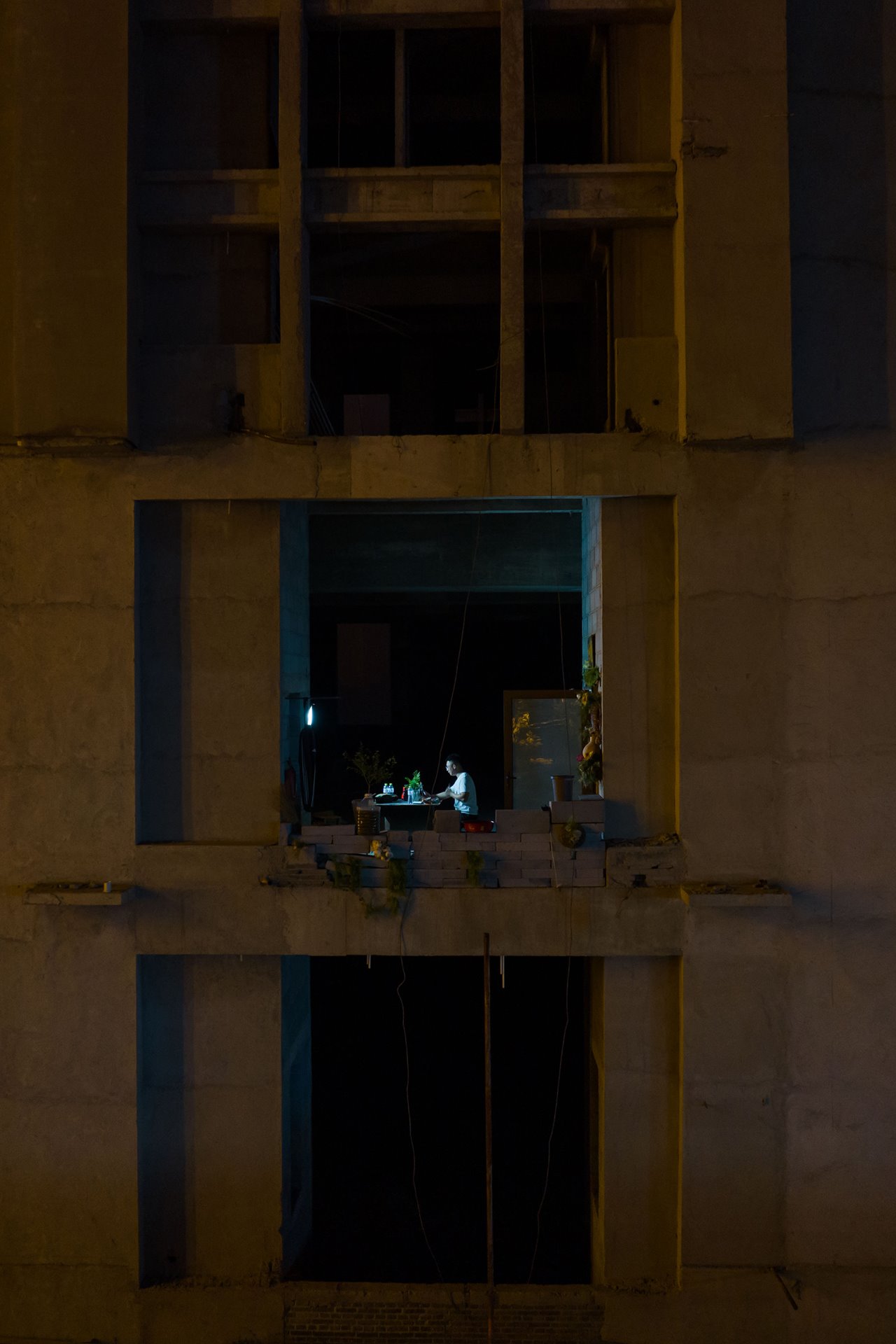 <p>An unfinished building in Qingdao, China. The homeowner has been forced to build a makeshift barrier with bricks and stones. He is recording a live webcast. Although live streams are often throttled or blocked, many people continue to find ways to attract attention to their situations online.</p>
