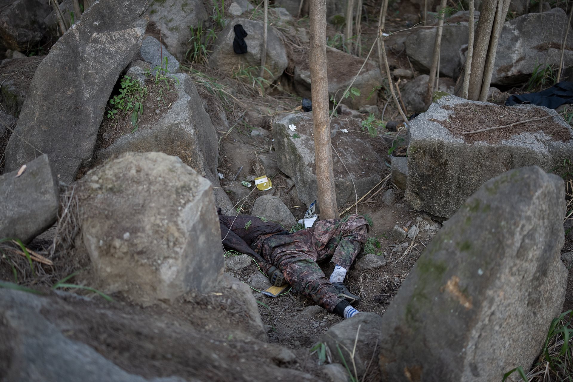 A body lies in the Vacaria forest in Rio de Janeiro, Brazil, where 74 victims were discovered following an alleged police ambush. Authorities failed to deploy forensic experts to the site, violating a 2025 resolution mandating immediate investigations into all police killings.