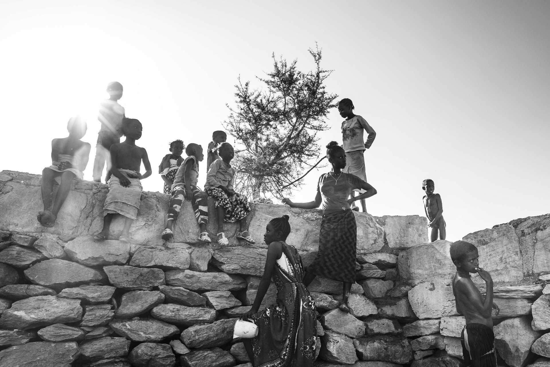 Tigrayan schoolchildren play with well water after school in Sheraro, Tigray, Ethiopia. Schools offer socialization, learning, and emotional stability. According to Unicef, children in school are less at risk of exploitation, sexual violence, early marriages, and child labor. Yet, due to conflict and COVID-19, Ethiopia faces a severe educational crisis, leaving many children without consistent access to education, despite peace agreements.