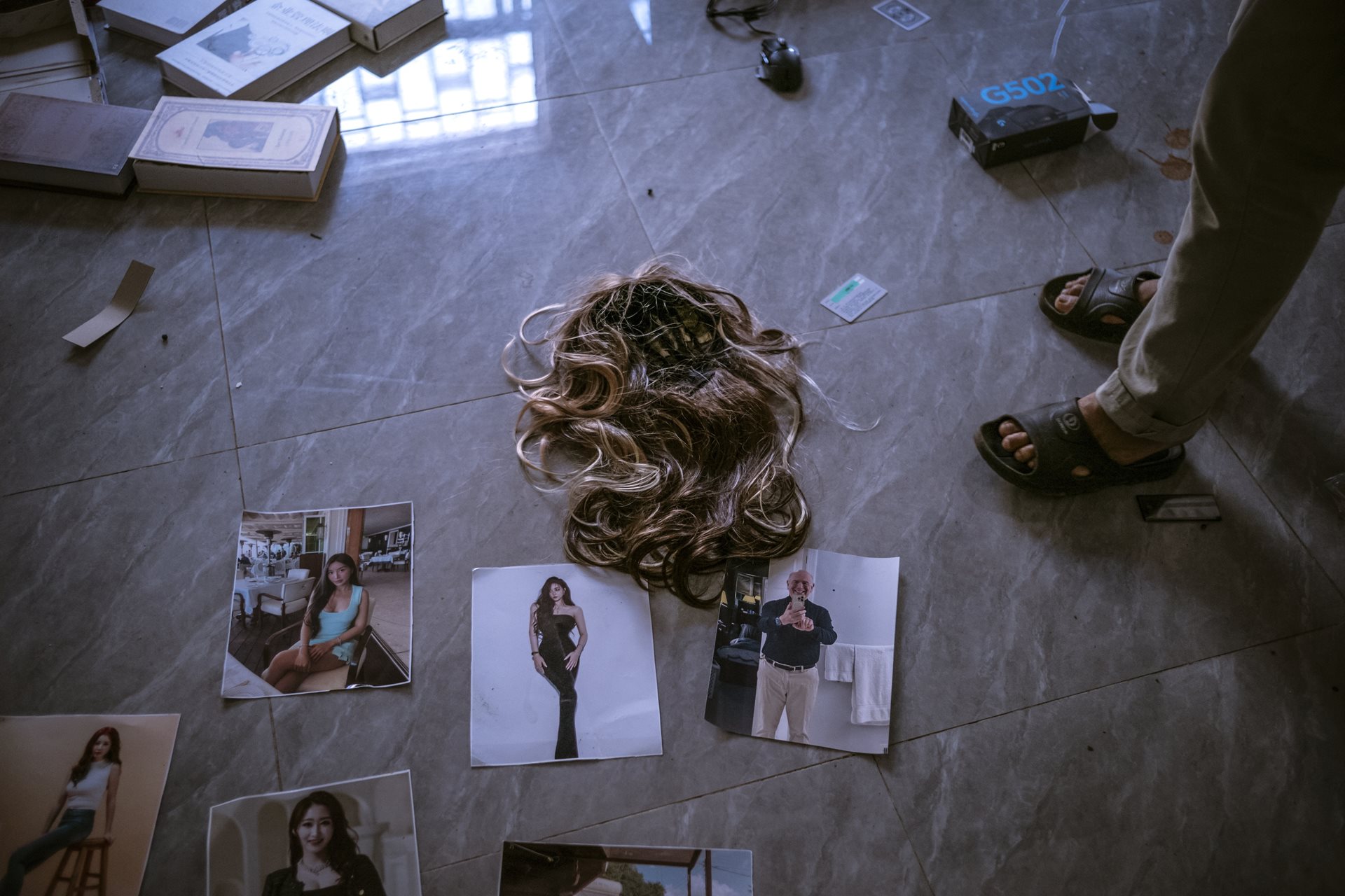 Photographs and props used to fake online personas and build relationships with victims. Scam manuals found on-site instructed workers on specific age groups to target by country, such as targeting women over 40 in Taiwan, to maximize the psychological impact of the fraud. Min Let Pan, Myanmar.