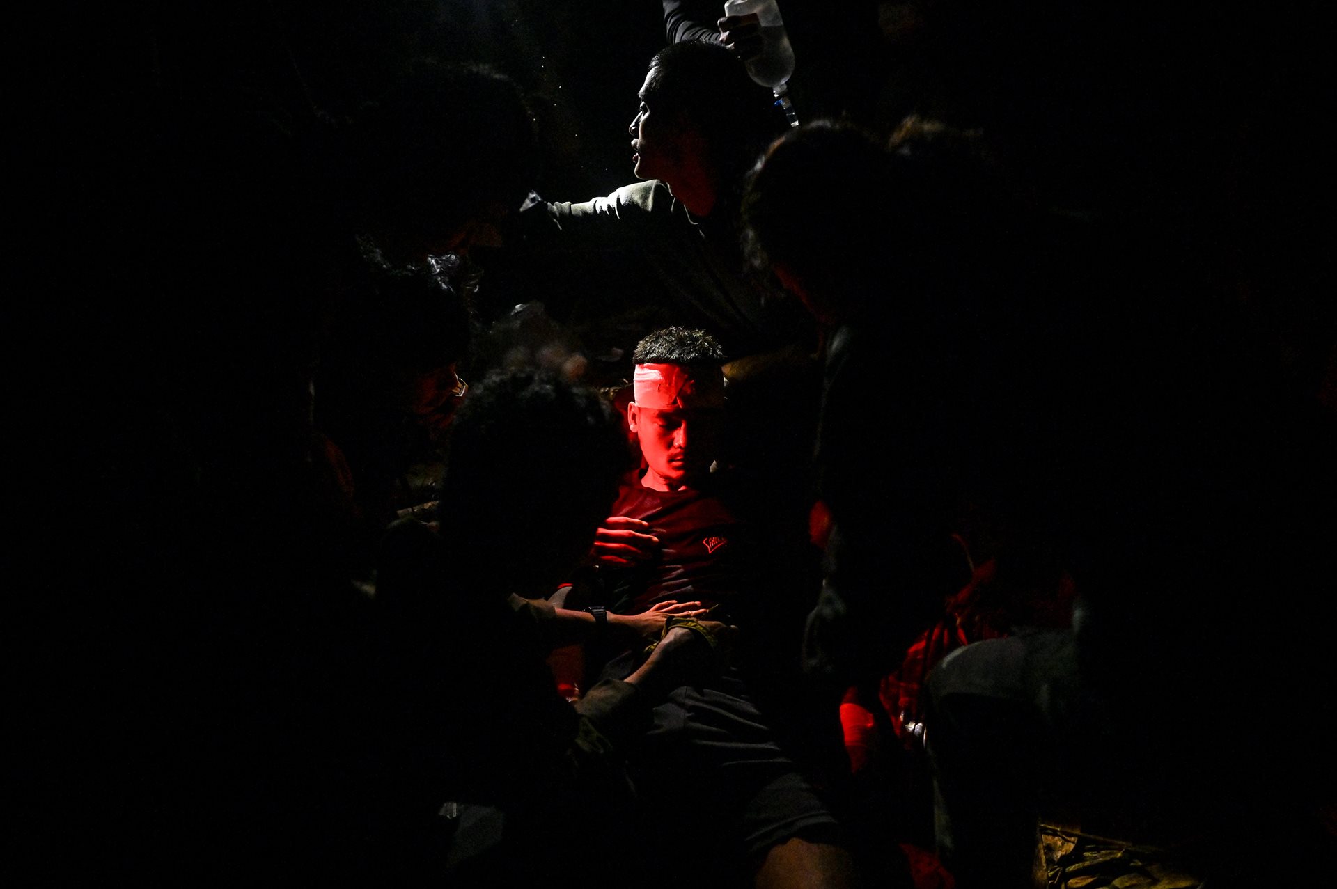 A medic from the Free Burma Rangers (center) receives treatment from fellow medics after being injured in an airstrike by the military junta air force, in Moe Bye, Shan State, Myanmar. Despite sustaining a head injury, he survived the attack. Moe Bye was strategically important to the military, as it gave them access to areas where armed resistance was strong.&nbsp;