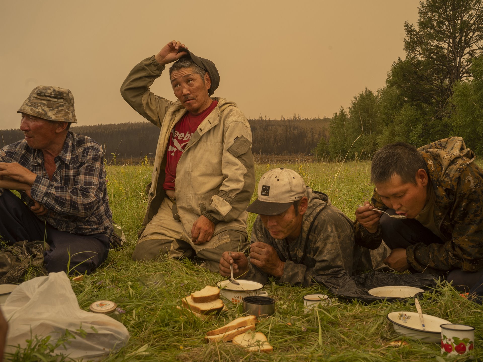 Local firefighting volunteers take a break for food in Magaras, central Sakha, Siberia, Russia.