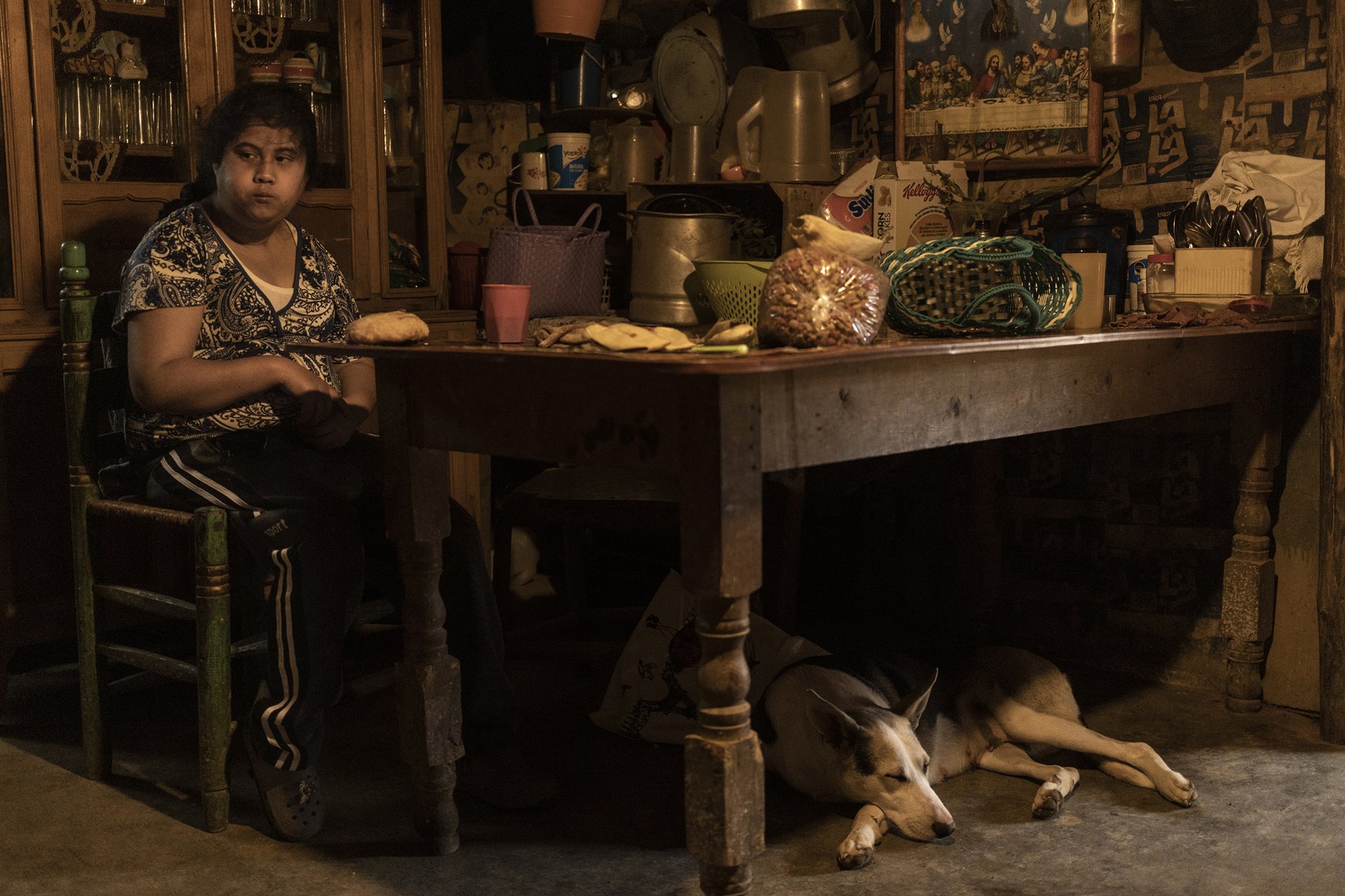 Alicia (16), who lives with Down syndrome, eats a meal in &nbsp;the home she shares with her mother, in the midst of greenhouses in Villa Guerrero, Mexico.