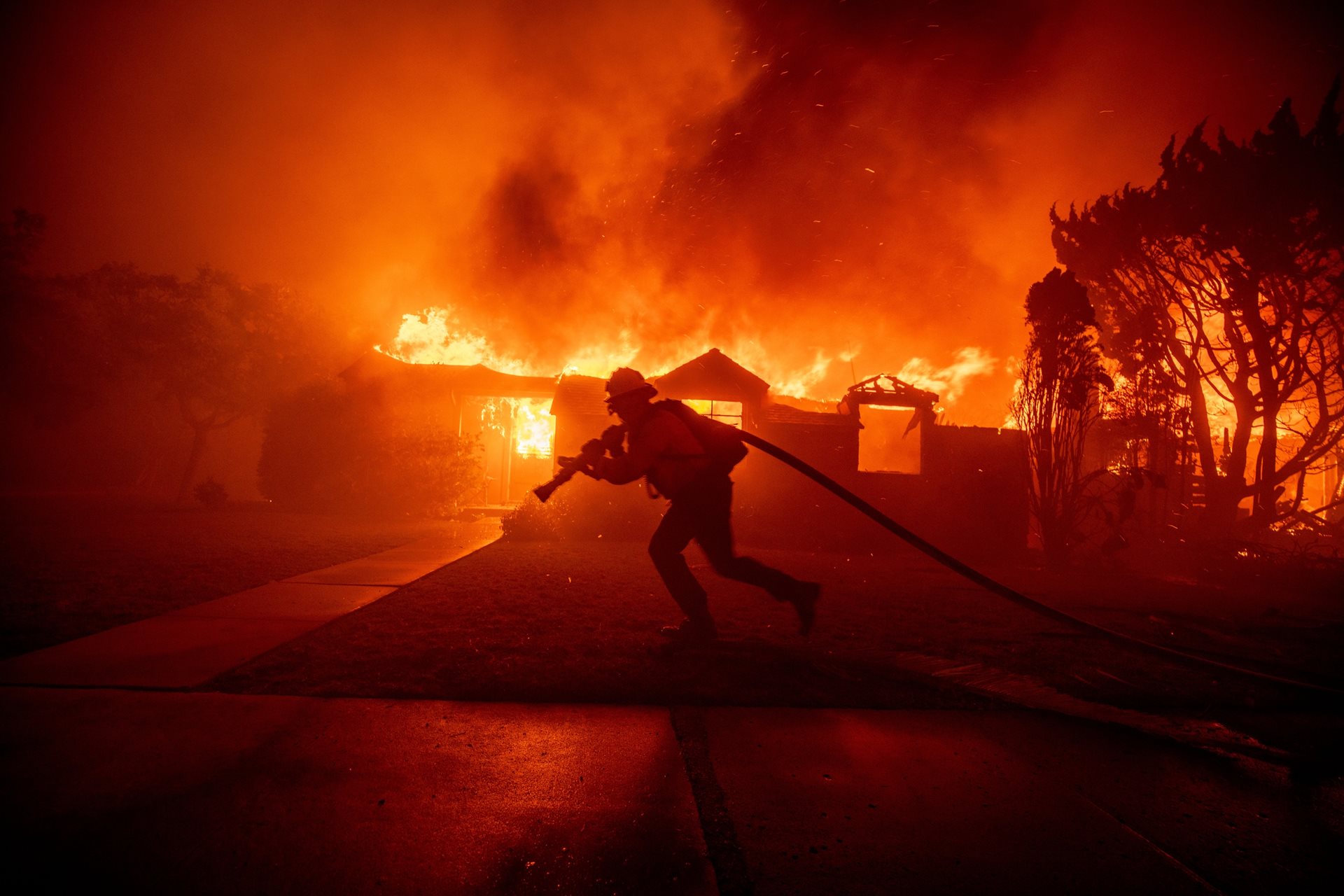 <p>A firefighter battles the Palisades Fire as a structure burns. Population growth near dry, grassy landscapes in Los Angeles makes the city more vulnerable to man-made sparks that ignite fires.&nbsp;<br />
Los Angeles, California, United States</p>
