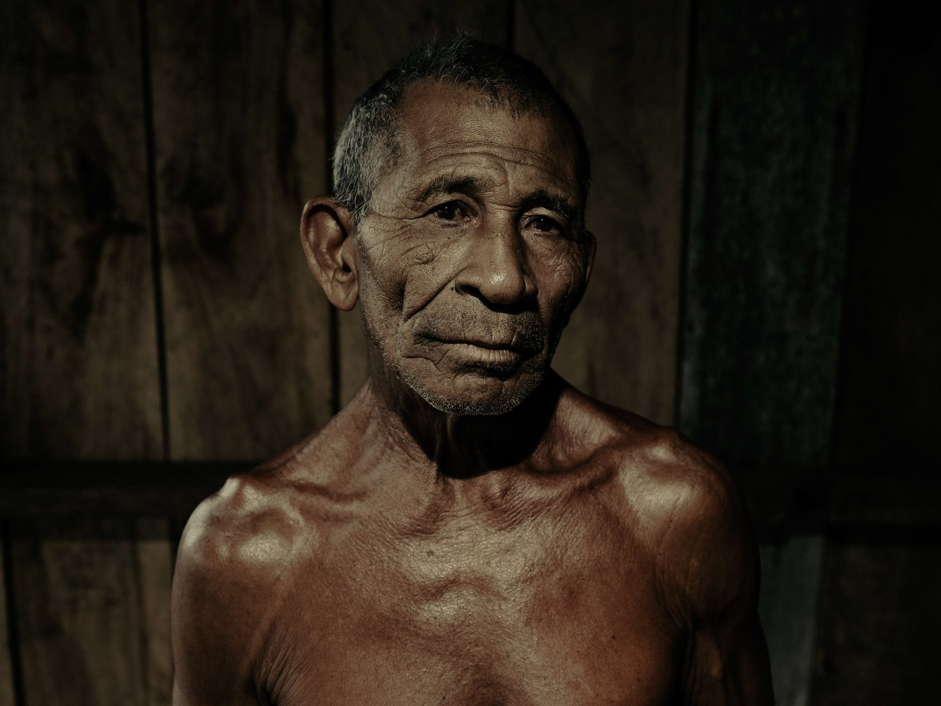 Raimundo Silva Do Carmo, (69) was a boatman for many years. Now he is a merchant working from a floating boat in Puraquequara Lake, which has almost completely dried up due to the droughts. Amazonas, Brazil.