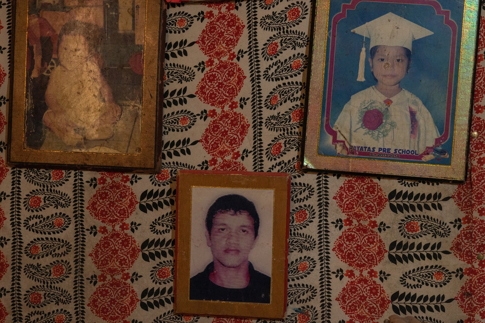 A portrait of Constantino de Juan is on display alongside those of children, at the family home in Payatas, Quezon City, the Philippines. He died during a police raid in December 2016, and his death certificate indicates he died of a heart attack.