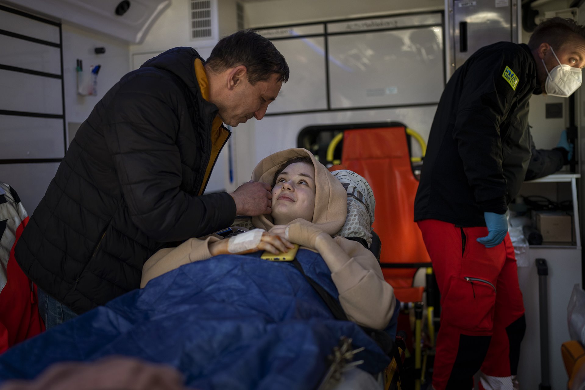 Nastia Kuzik (21) says goodbye to her father inside an ambulance, at a public hospital in Kyiv, Ukraine, as she is transferred to Germany for further treatment. Nastia lost her right leg below the knee and suffered serious injury to her left leg when she was caught in bombardment on the way back home from a visit to her brother, in Chernihiv, on 17 March. The city of Chernihiv, in northern Ukraine, was under siege from 24 February to early April.