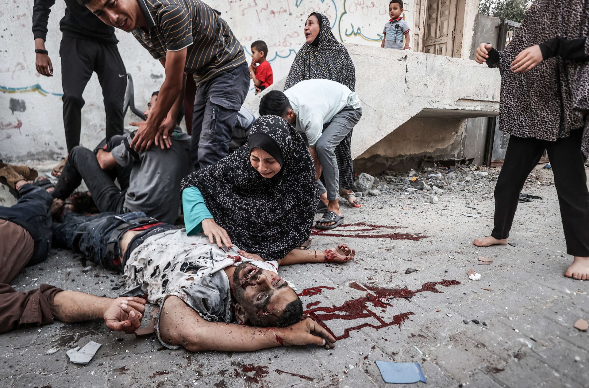 People mourn by the body of a man killed during Israeli bombardment of a neighborhood in Deir al-Balah, Gaza. Attacks carried out that day on the northern and southern parts of the city killed 27 people, including around 12 women and children.&nbsp;