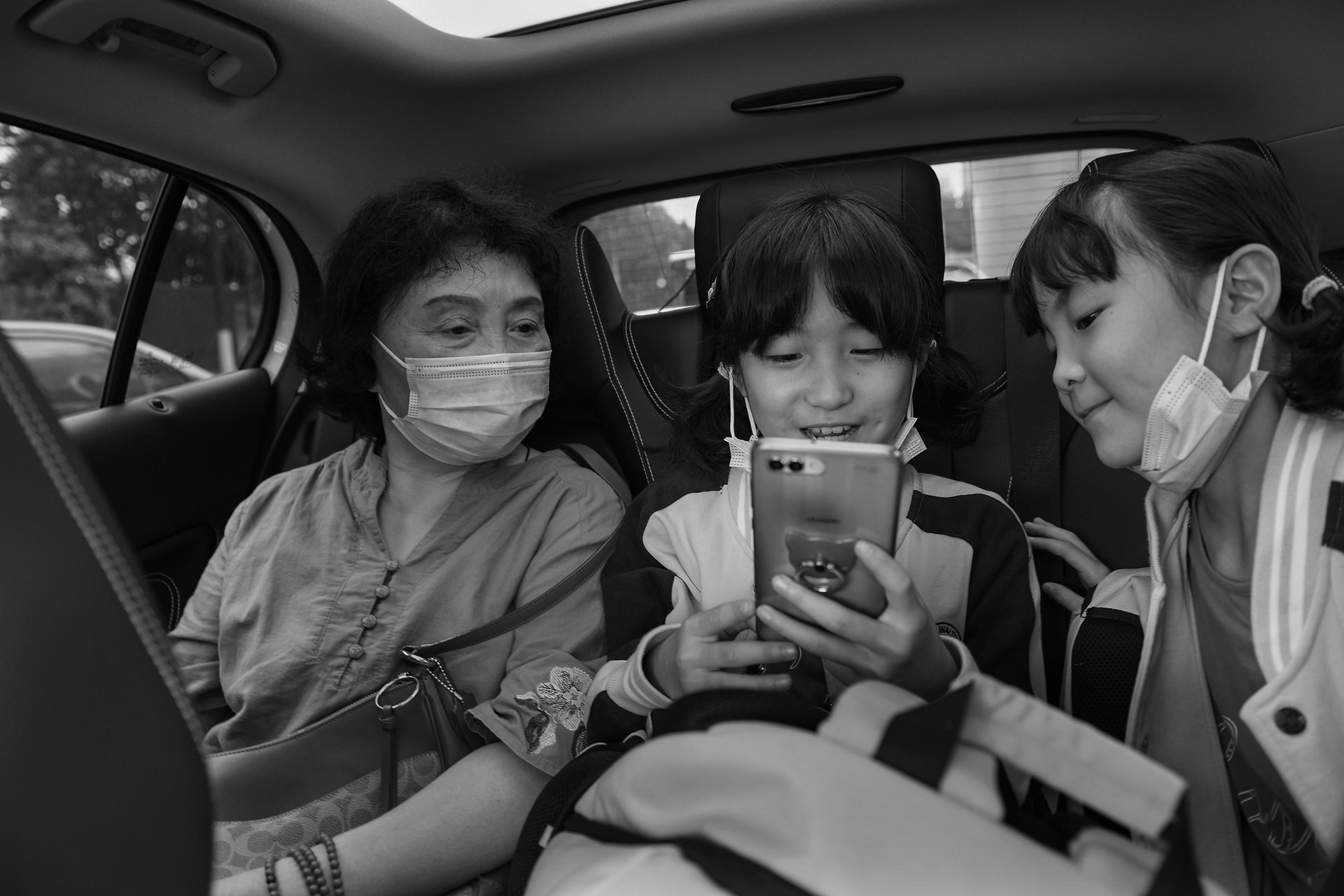 Sheng Hailin picks up her daughters from their boarding school in Hefei, Anhui Province, China. To manage the household, Sheng Hailin eventually enrolled the girls in a boarding program to ensure their education continued while she managed her husband's care.