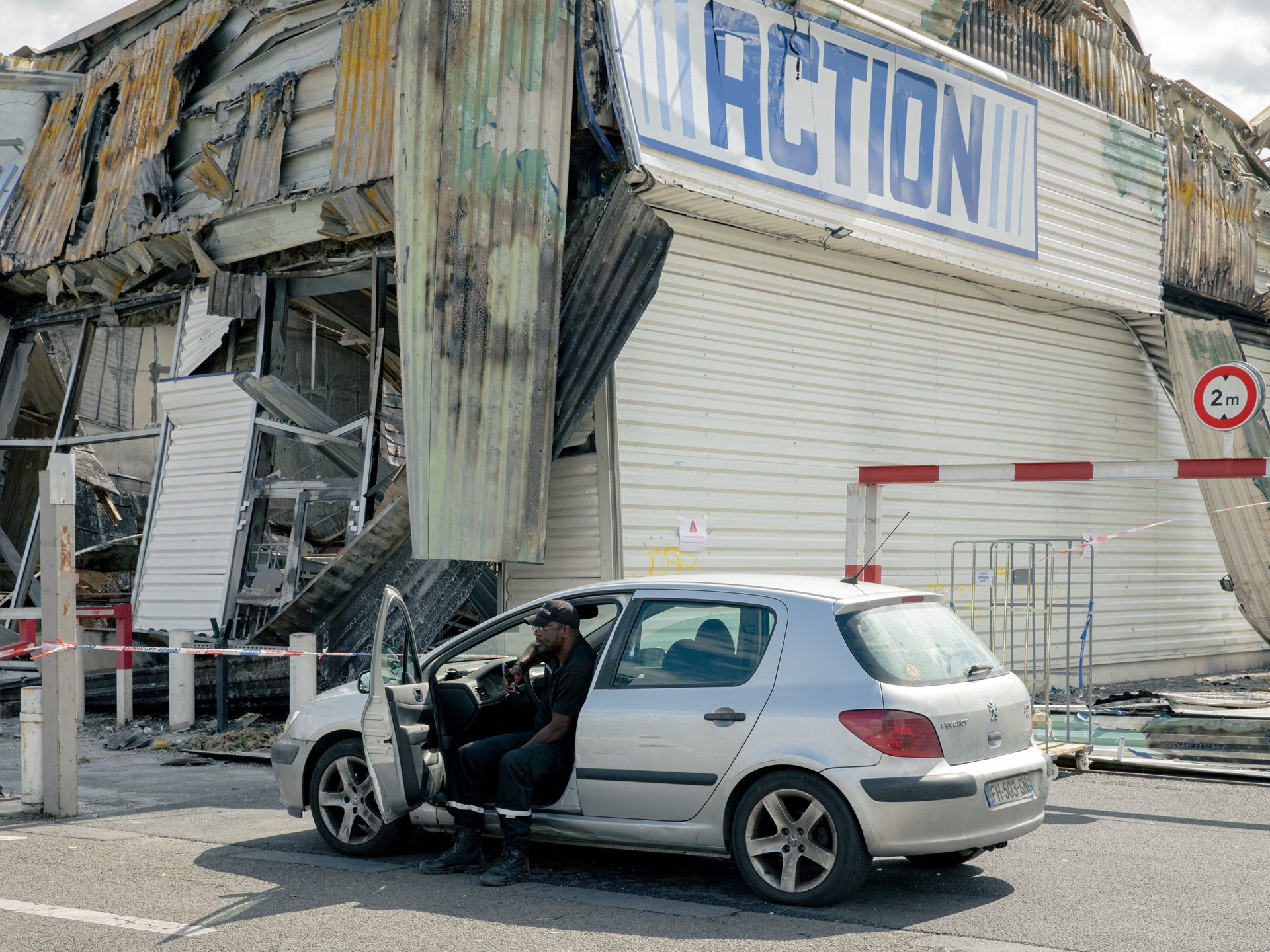 <p>A security guard watches over a burned-out Action discount store in Sevran, France, the day after a night of rioting following the killing of Nahel Merzouk (17), shot by a police officer in Nanterre.&nbsp;</p>
<br />
&nbsp;