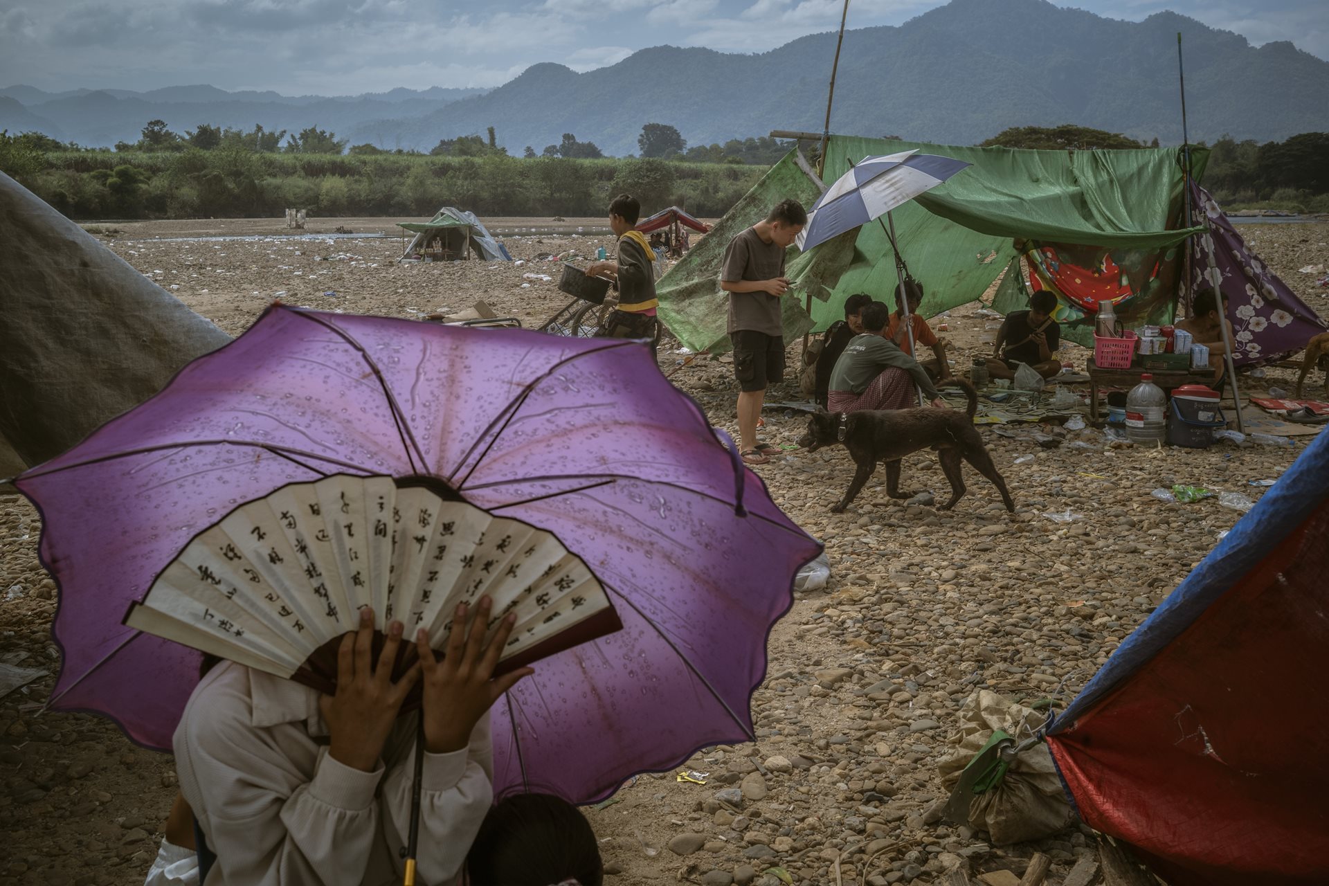 Stranded workers at a makeshift shelter near the Moei River in Min Let Pan, Myanmar. Many workers had their documents and passports seized by the scam center bosses and could not cross the border into Thailand.