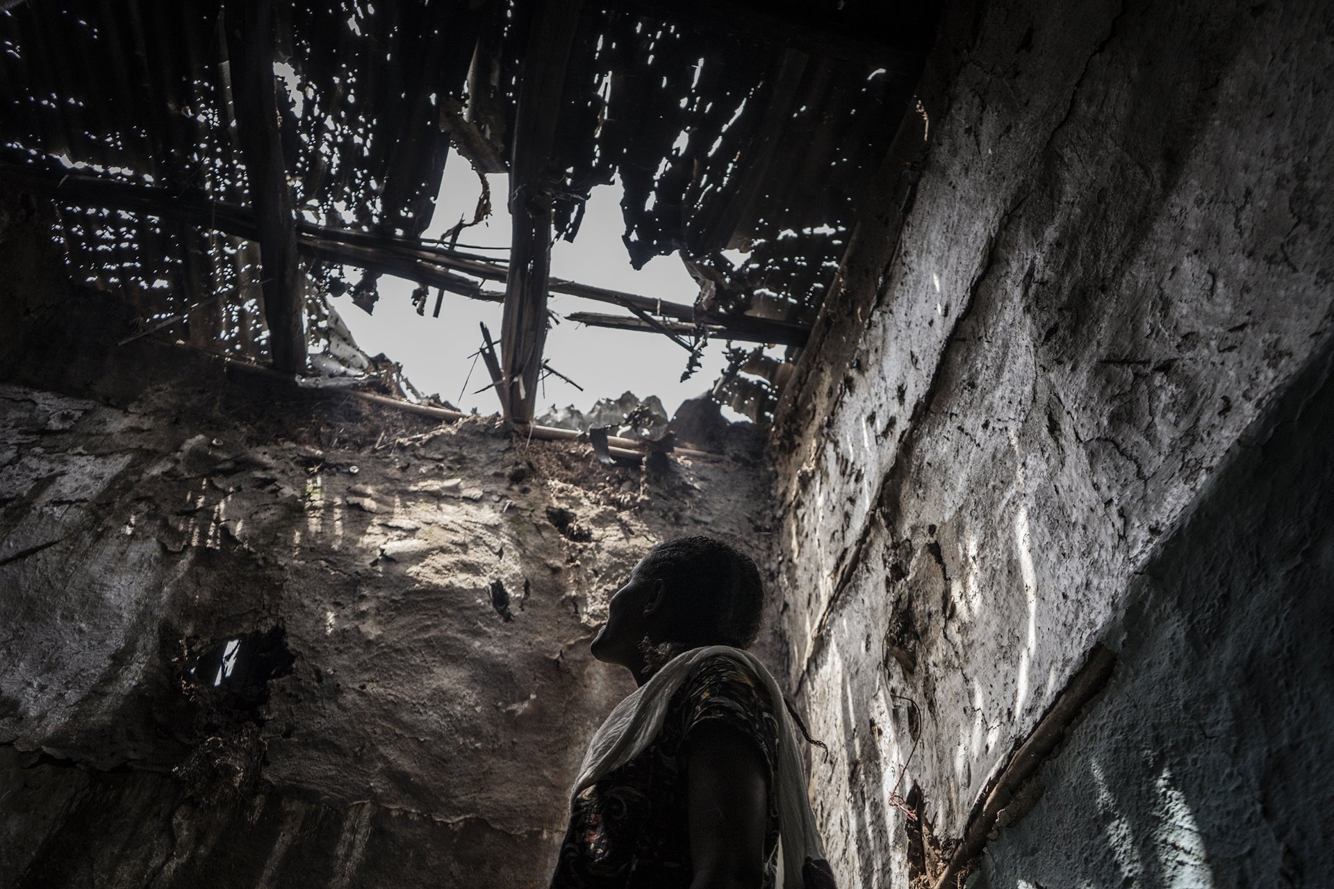 Abeba Tseganeh indicates the roof of her house, allegedly attacked by pro-Tigray fighters in the village of Zarima, 140 kilometers from Gondar, Amhara, Ethiopia. Zarima is reported to have been the stage for a battle between Ethiopian and pro-Tigray forces.