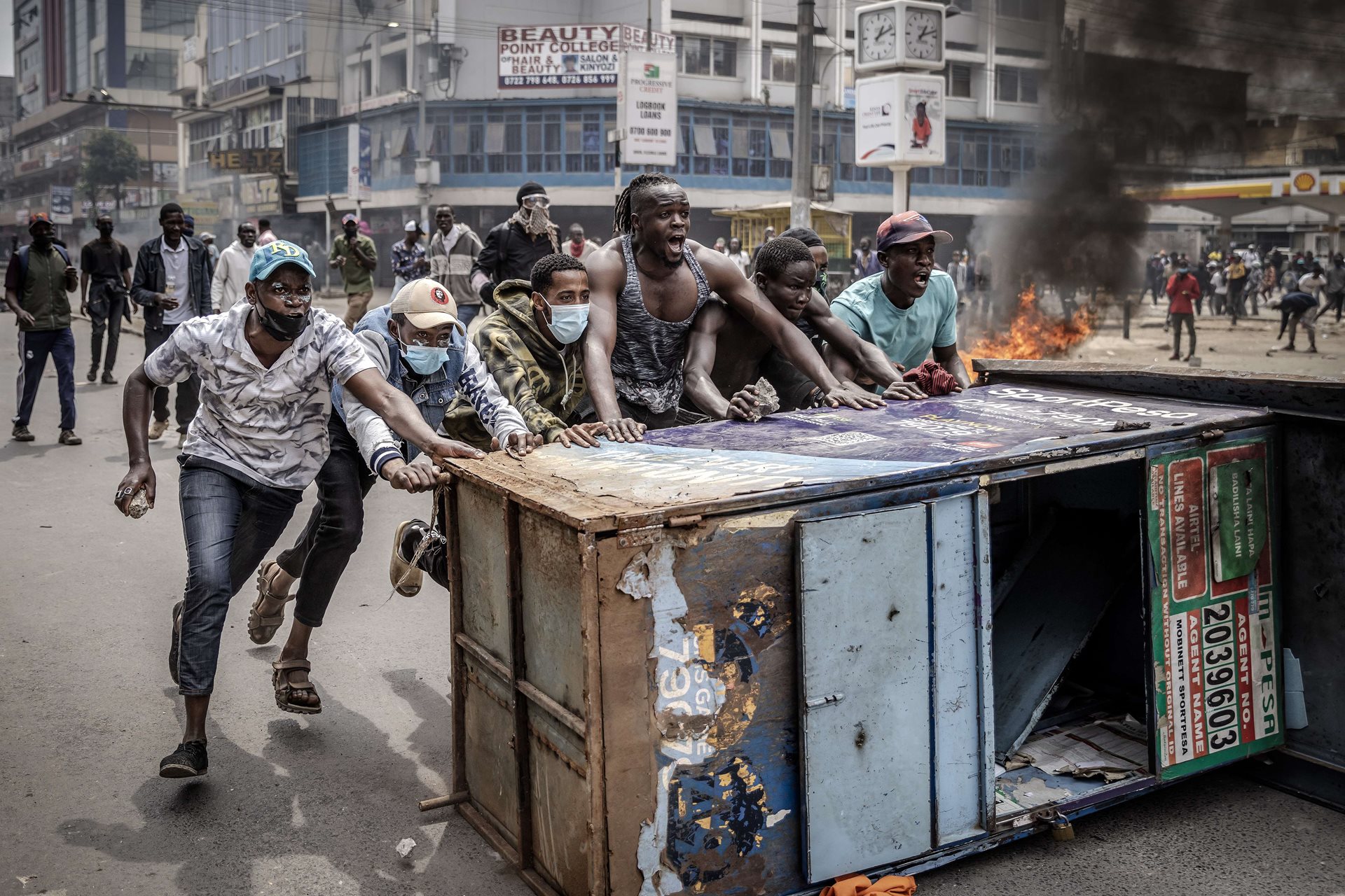 Protestors chant slogans and push a makeshift barricade as they clash with Kenyan police officers during an anti-government demonstration in Nairobi, Kenya.