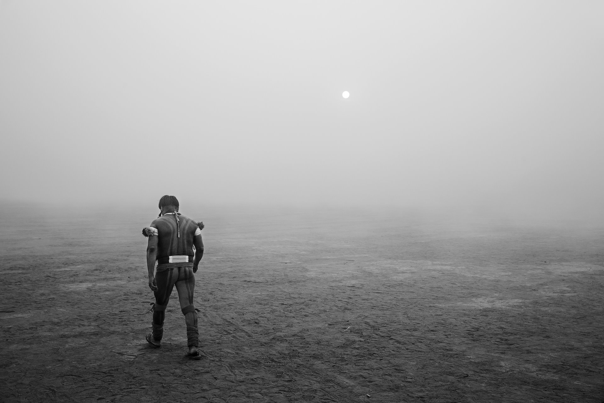 A man walks near the village of Yawalapiti, amidst smoke from bush fires in the Xingu Indigenous Park, in the Brazilian Amazon. Deforestation in the park has caused an increase in local temperature and a drier microclimate. This has led to an increase in forest fires, as well as threatening the traditional way of life of the Indigenous populations who live there, as it has made subsistence farming more difficult and increased their dependence on industrialized food.