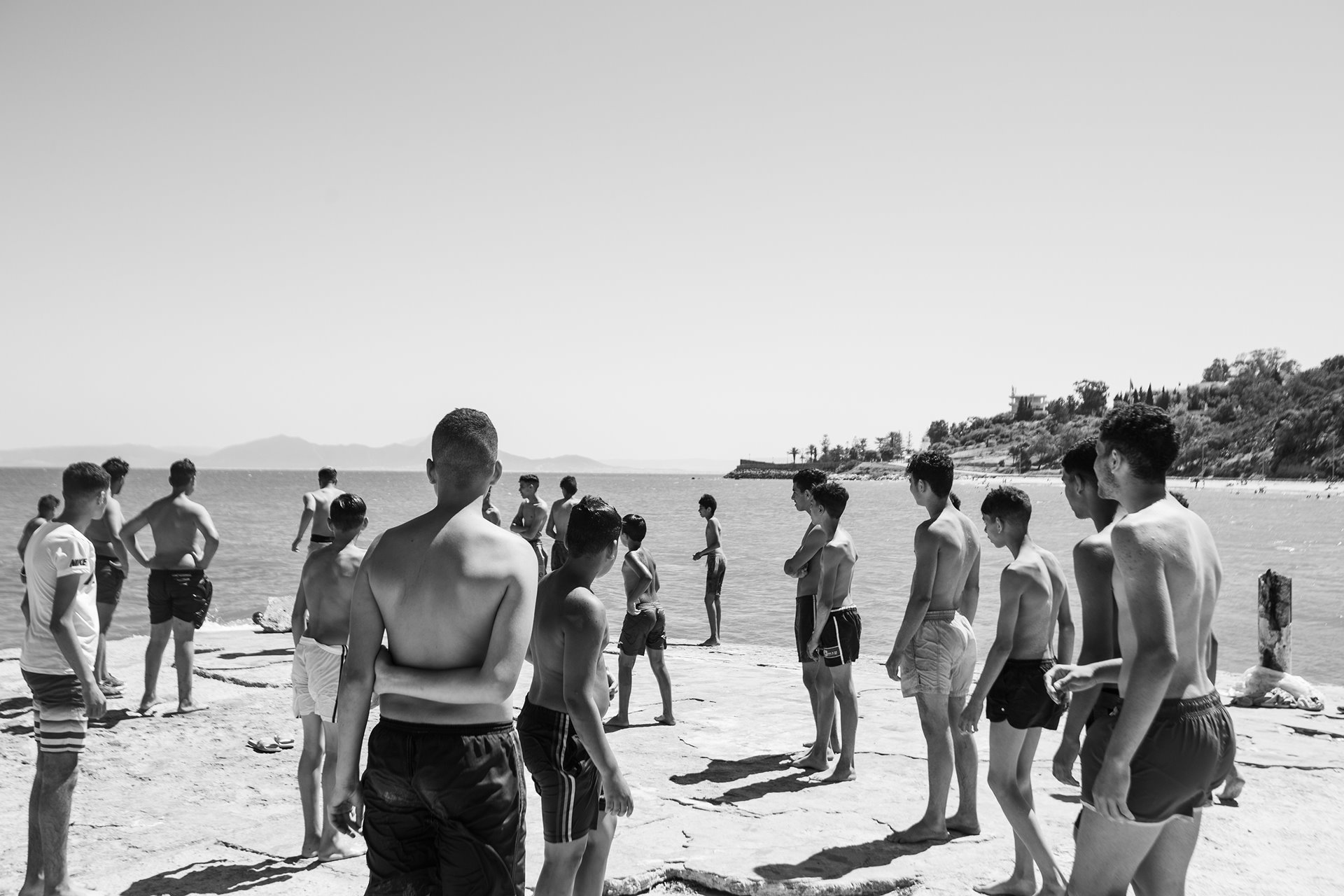 Young men gather on the beach at Sidi Bou Said Beach, Tunis, Tunisia. Easily accessible by train, the beach is a meeting place for young people from different social classes.