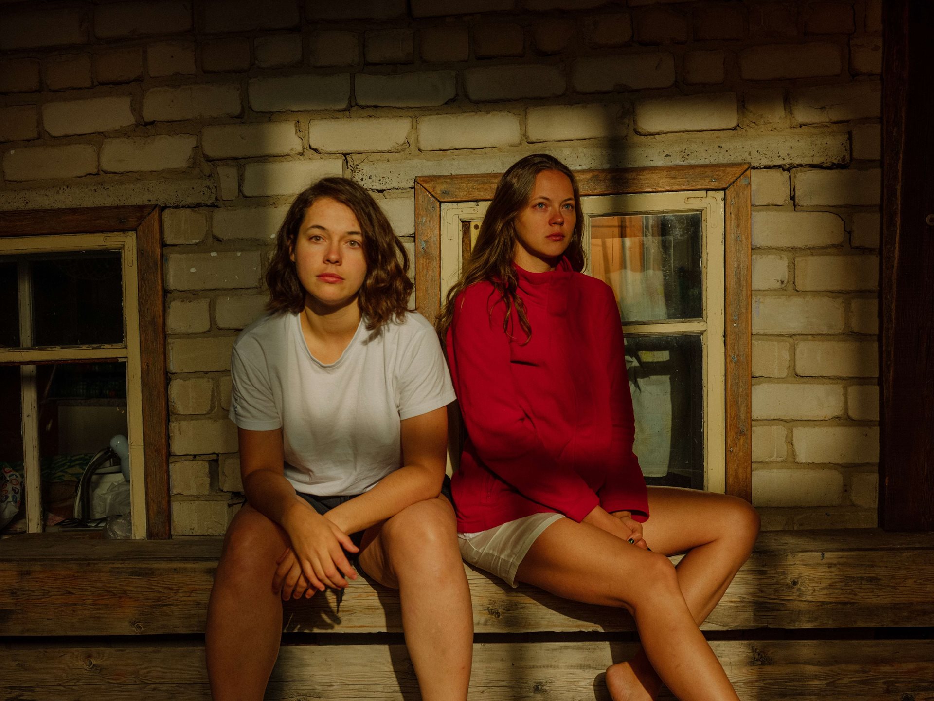Aliona (left) sits with her younger sister Sanya, a mother of two, at the house where they grew up, in Tomsk, Russia. Aliona says there has long been an unspoken consensus between them that they are too different to be friends. Aliona has never talked to Sanya about the war and has no idea of what it must be like to raise a son in wartime Russia.&nbsp;
