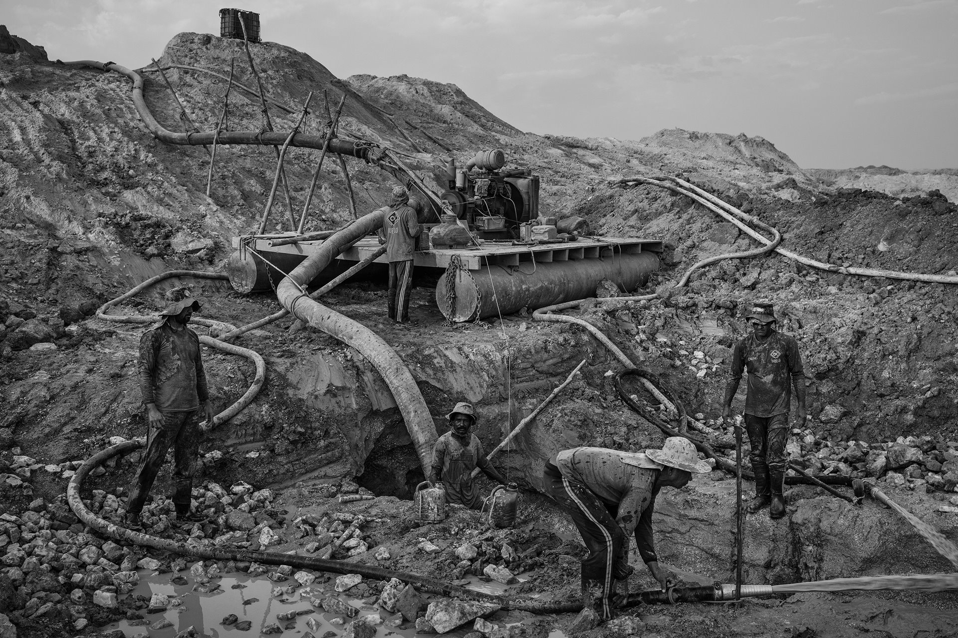 Men work on an open-pit gold mine in Peixoto de Azevedo, in northern Mato Grosso, in the Brazilian Amazon. Mato Grosso is one of the largest gold-producing areas in Brazil. Part of the extraction activity in the region is illegal, and even legal mines often do not comply with environmental legislation, due to lax enforcement by the Brazilian authorities. The result is polluted rivers and degraded regions of areas once covered by rainforest.