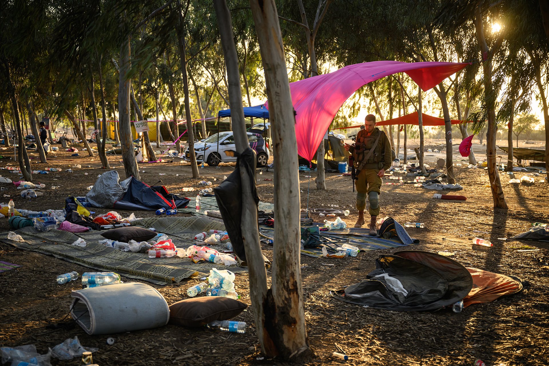 An Israeli security forces officer searches the site of the Supernova music festival for personal effects of victims of the 7 October Hamas attack, which resulted in around 1,200 deaths, more than 2,500 reported injuries, and some 250 people held hostage from the festival and communities near the Gaza border. Re&rsquo;im, Israel.