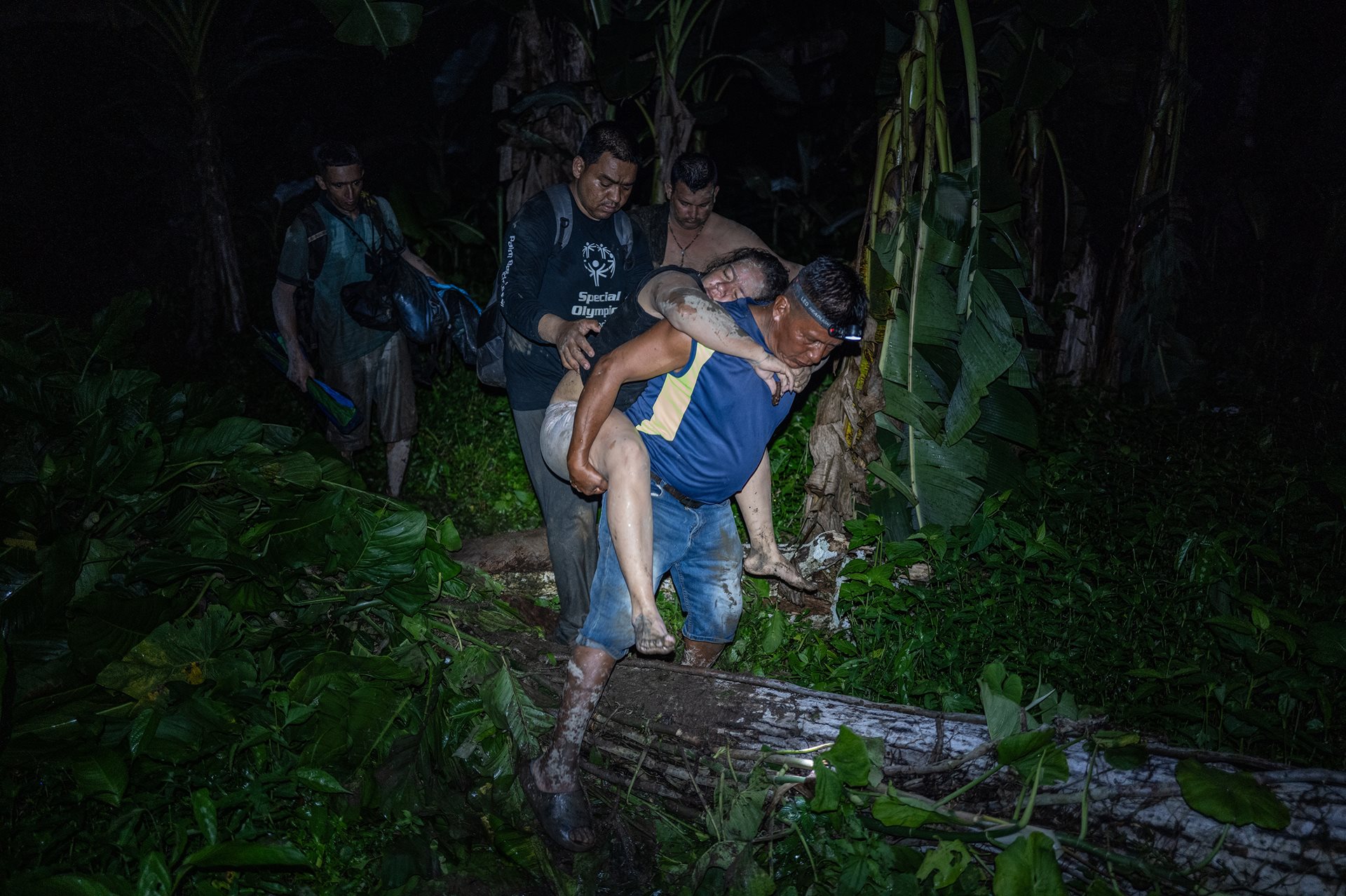 Rubén Guaynora, a local indigenous man, carries Kimberly Rodriguez, a Venezuelan who fainted several times while crossing the Darién Gap. He will help her onto a canoe that will transport her to Bajo Chiquito, where she may receive medical attention. Darién Gap, Panama.