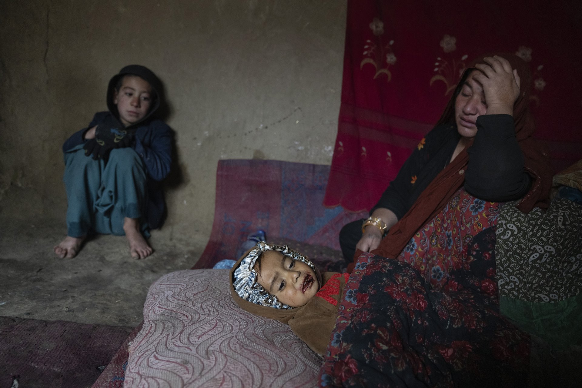 A woman cares for her sick child, in a camp for internally displaced people on the outskirts of Kabul, Afghanistan. She cannot afford medical treatment.