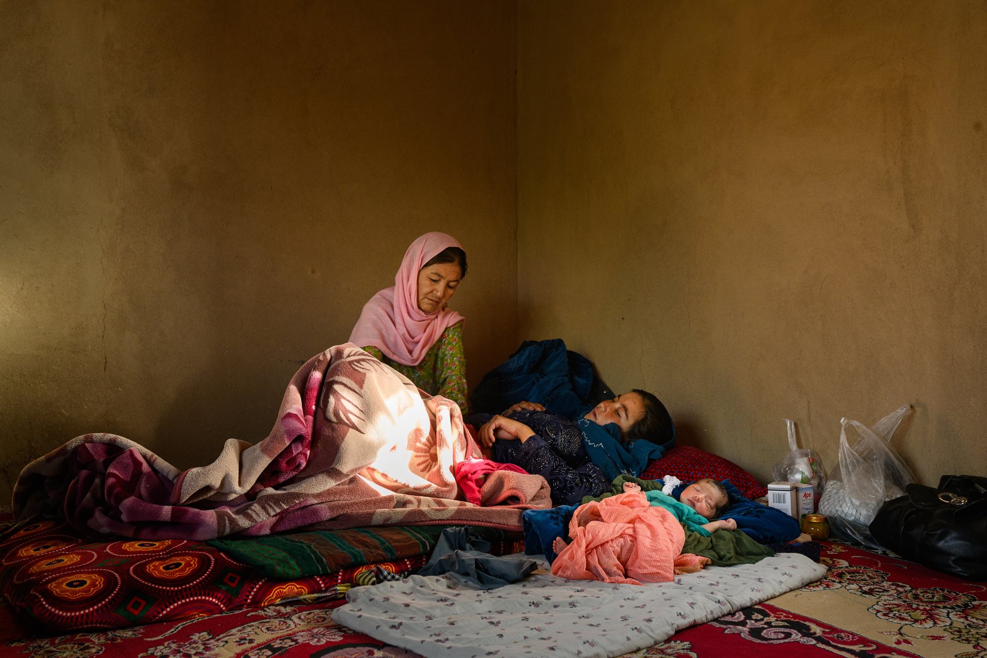 Gulshaman visits Fatemah, whose daughter Yasmin was born the previous day. Waras, Shahristan district,&nbsp;Daikundi province, Afghanistan.