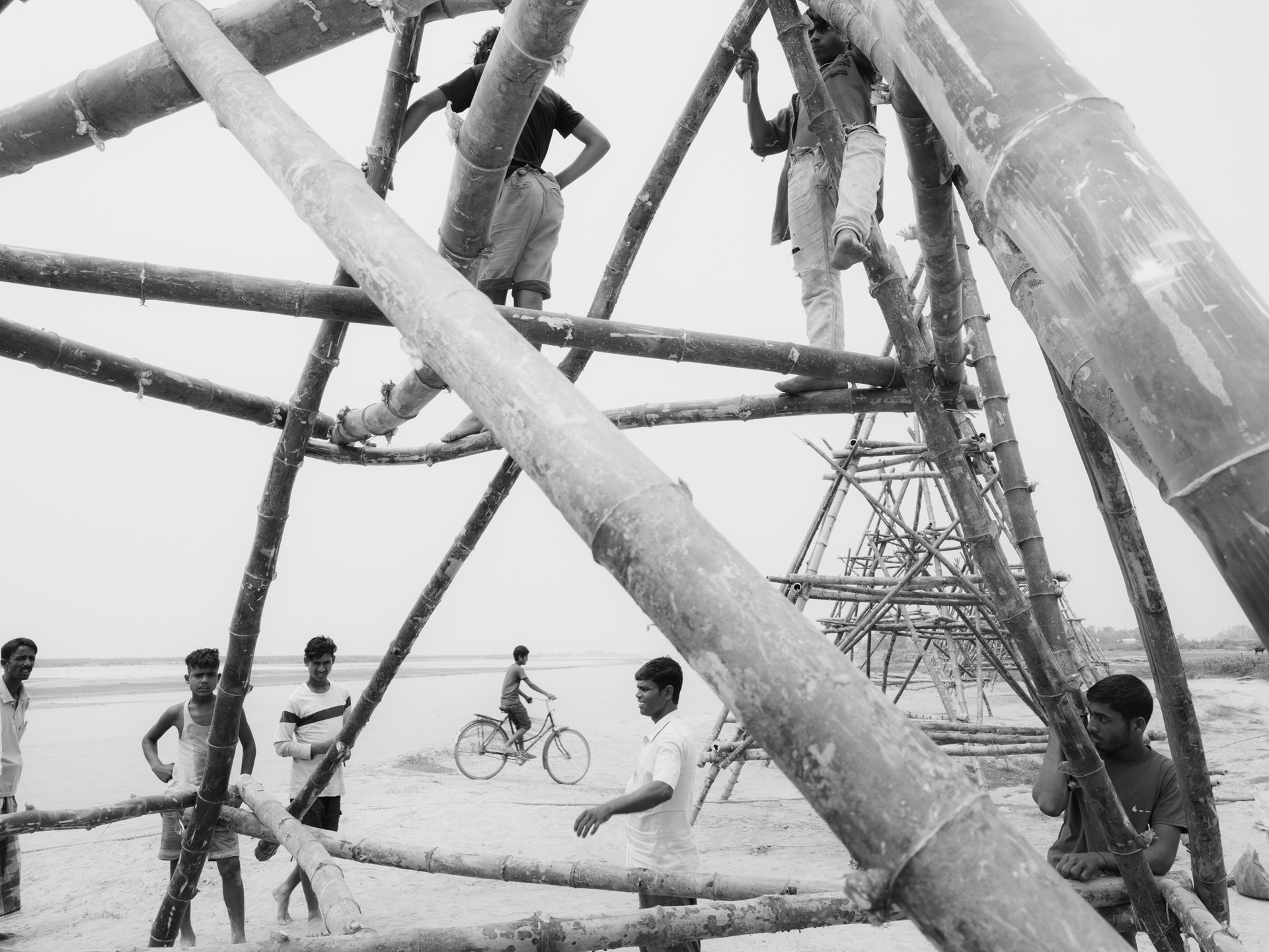 Village volunteers construct bamboo pods or &quot;porcupines&quot; to combat erosion. Indigenous communities rely on traditional methods to mitigate the Brahmaputra&#39;s aggressive erosion. These pods, placed on char edges before monsoon, entangle river vegetation, slowing the flow of the Brahmaputra and reducing soil damage. While the government has attempted concrete versions of these pods since 1980, they proved ineffective, prompting communities to revert to time-tested methods honed over centuries of enduring and mitigating environmental challenges. Tarabari, Bahari constituency, Barpeta district, Lower Assam, India.