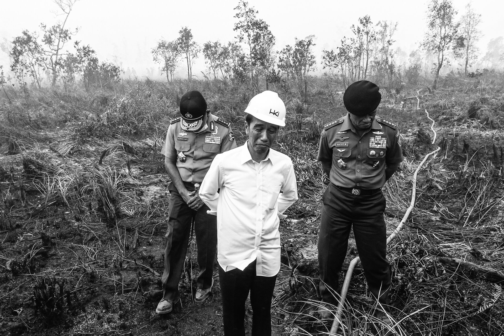 <p>Indonesian President Joko Widodo (center) accompanied by National Police Chief General Badarudin Haiti (left) and Indonesian National Military Commander General Gatot Nurmantyo (right) inspecting devastation caused by fire in Ogan Komering Ilir, South Sumatra. During this visit the president took action to punish companies that intentionally burn peatlands to plant oil palms.</p>
