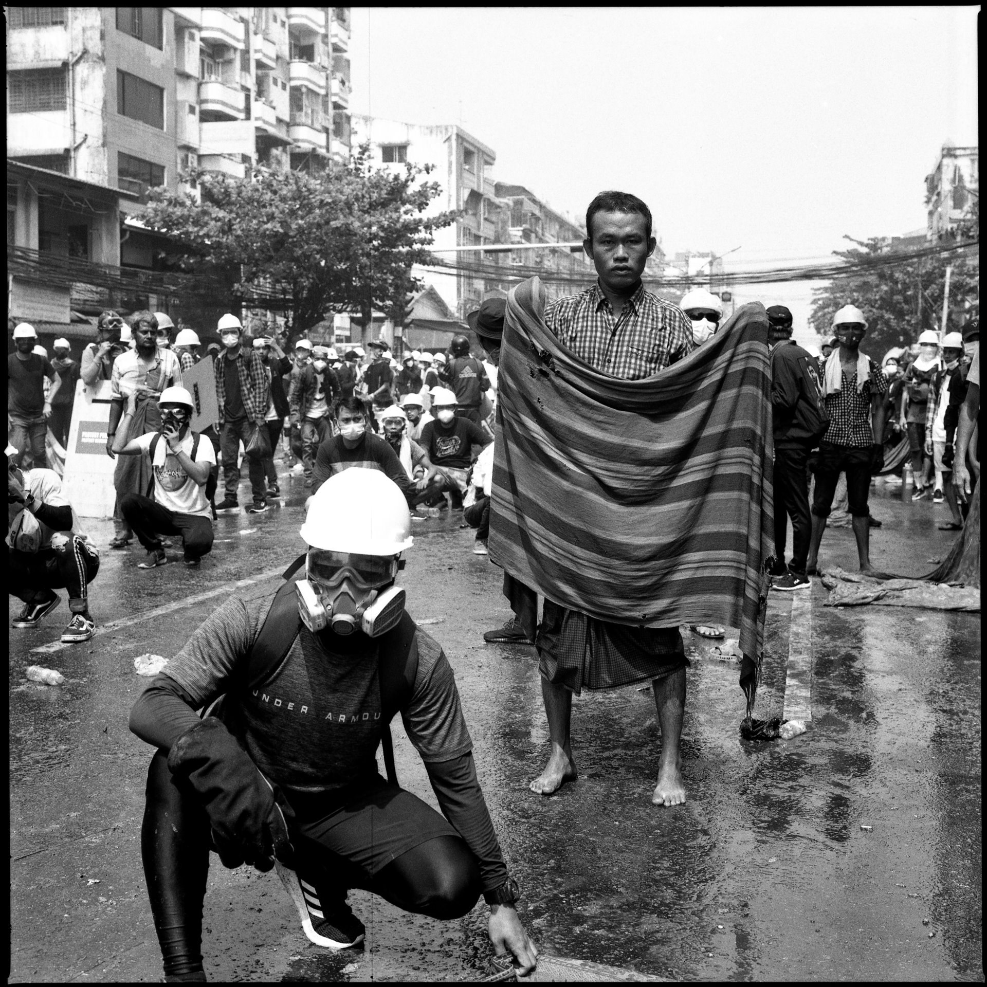 Anti-coup protesters prepare a wet blanket to catch oncoming teargas grenades during a confrontation with security forces in Yangon, Myanmar.&nbsp;