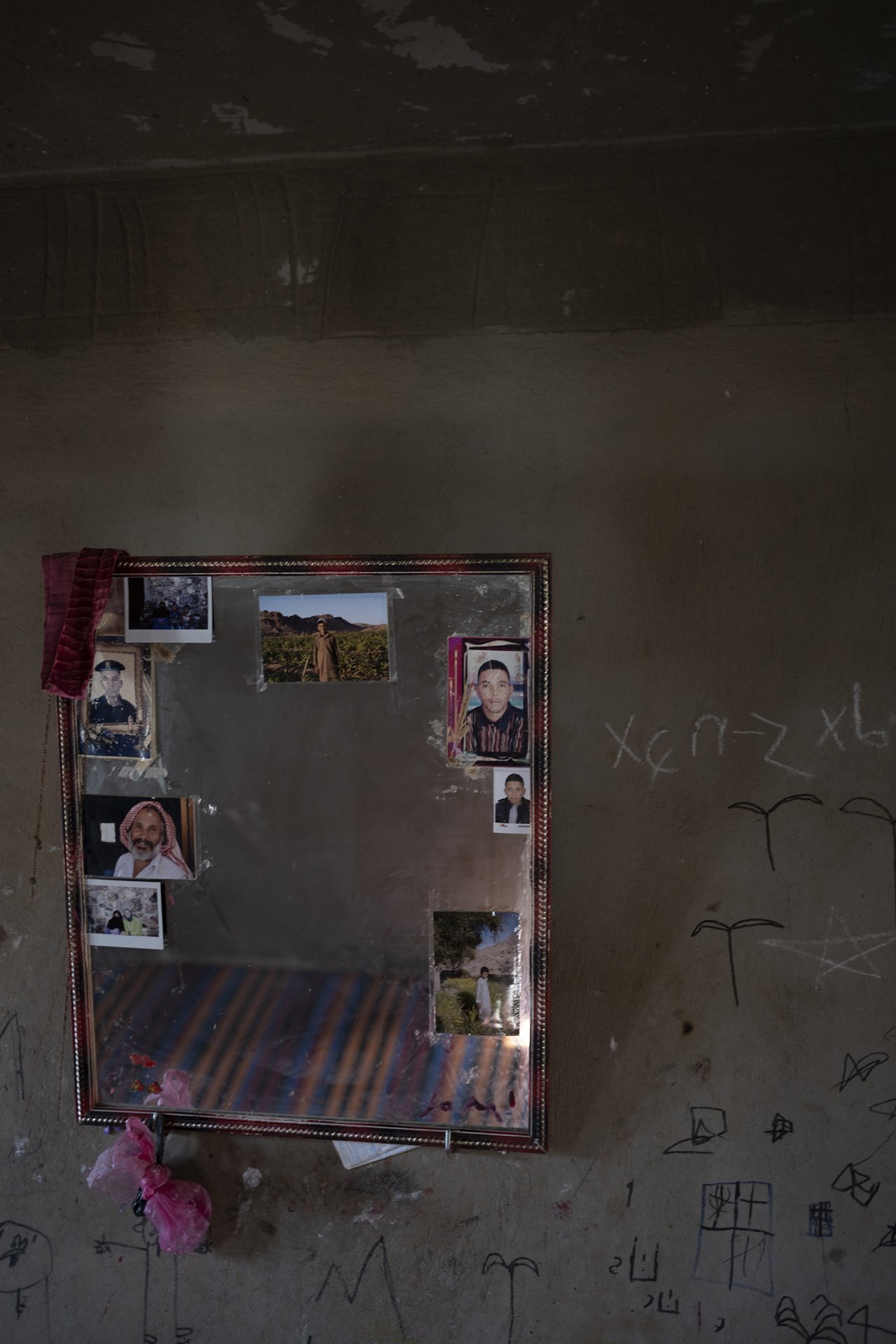 Photographs of male members of the family are hung around a mirror frame at the elder&rsquo;s family home in Al-Tarfa village, St. Catherine, South Sinai, Egypt.
