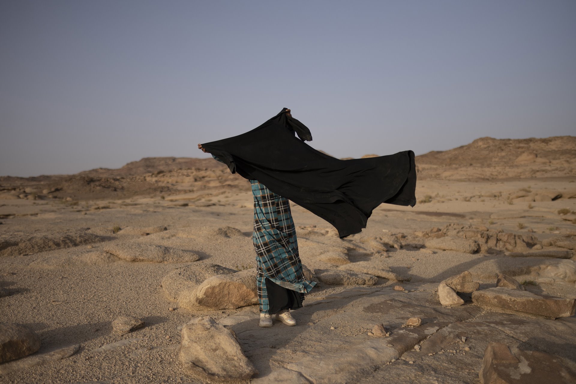 Zeinab holds an <em>abaya</em> (black dress) bought from the Gulf in Al-Tarfa village, St. Catherine, South Sinai, Egypt. Zeinab is soon to be married. As traditional Bedouin clothes disappear due to economic challenges, Bedouin women turn to the Gulf countries to buy clothes that share some similarities to their traditional garments.