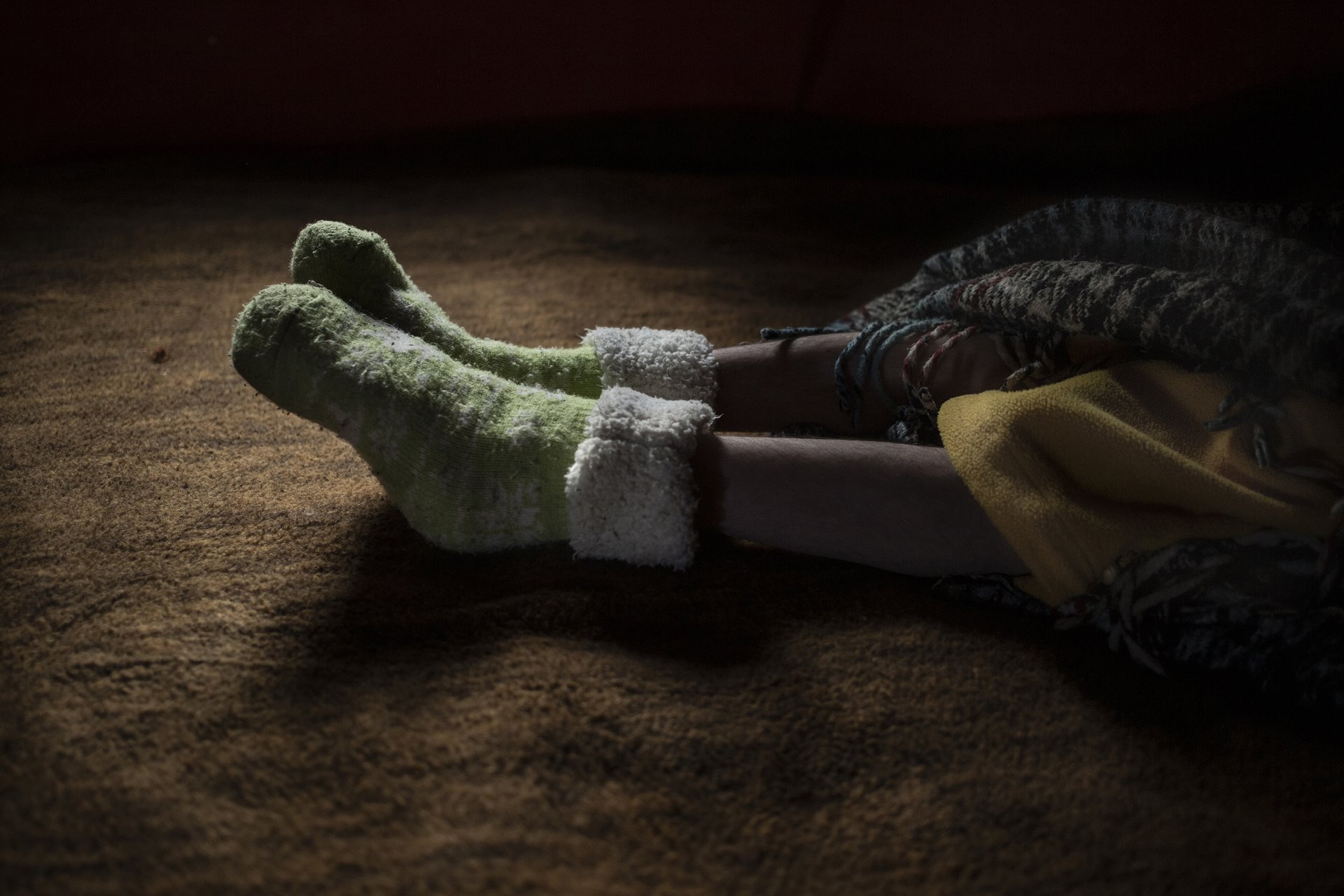 Sebastián (18), who lives with hydrocephalus (a neurological disorder caused by a build-up of fluids in cavities within the brain) lies in bed wearing socks his mother, Doña Petra, has put on him to keep his feet warm, in Villa Guerrero, Mexico. Sebastián depends on his parents for most daily activities.
