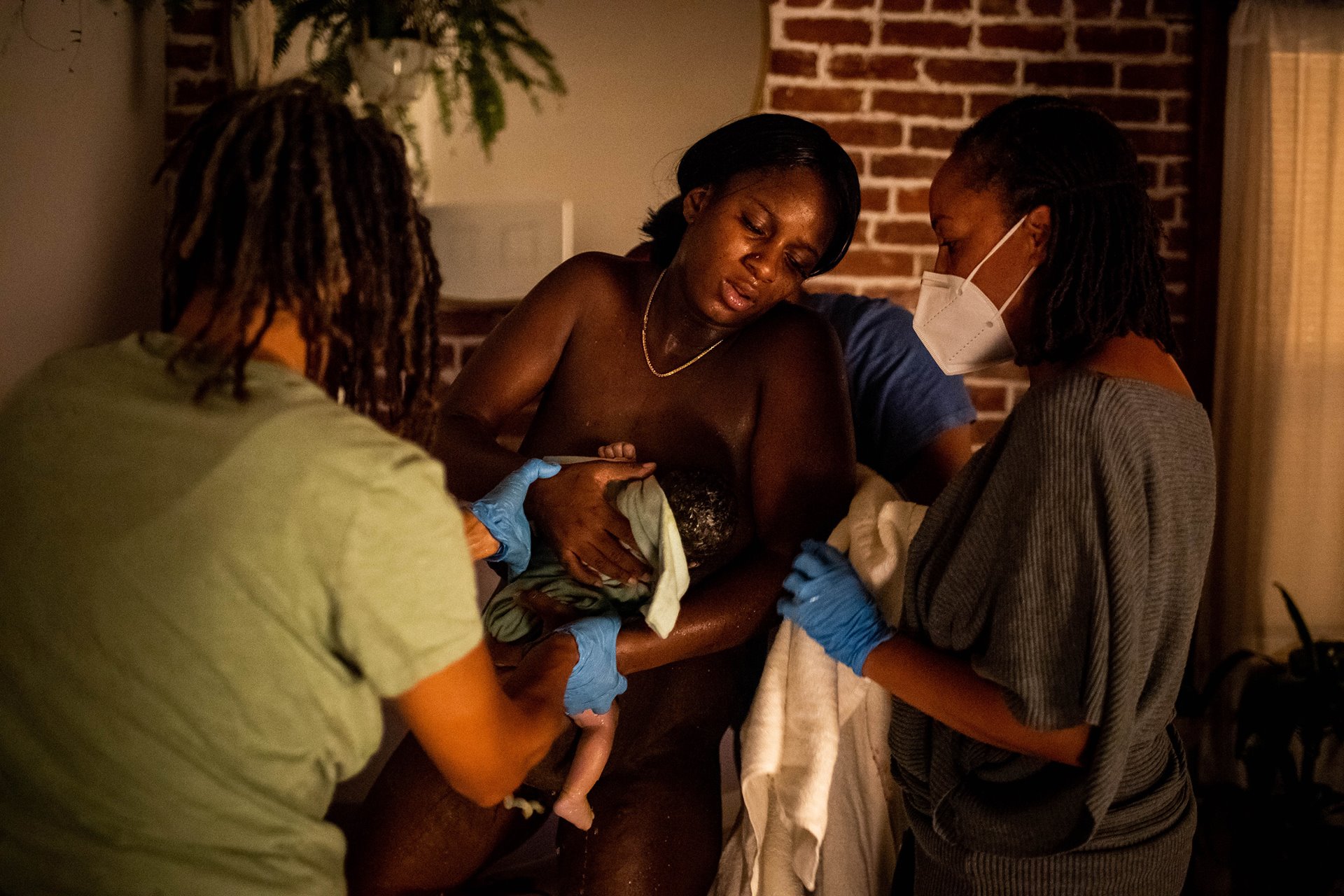Midwives Kimberly Durdin and Allegra Hill help Aysha out of the birthing bath at the Kindred Space LA birthing center, in South Los Angeles, USA. The two midwives opened their South Los Angeles birthing center during the COVID-19 pandemic.