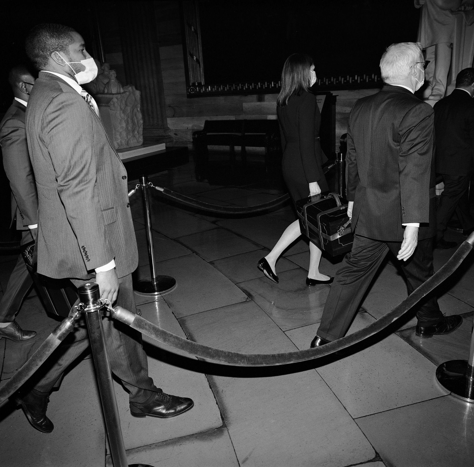 Staff carry chests containing state electoral college votes back to the Senate side of the Capitol, after an objection was raised to certifying the 2020 presidential election. Soon the Capitol was invaded, and staff hastened to safeguard the votes. After the rioters were dispersed by the police, the House and Senate certified Joe Biden&rsquo;s win.