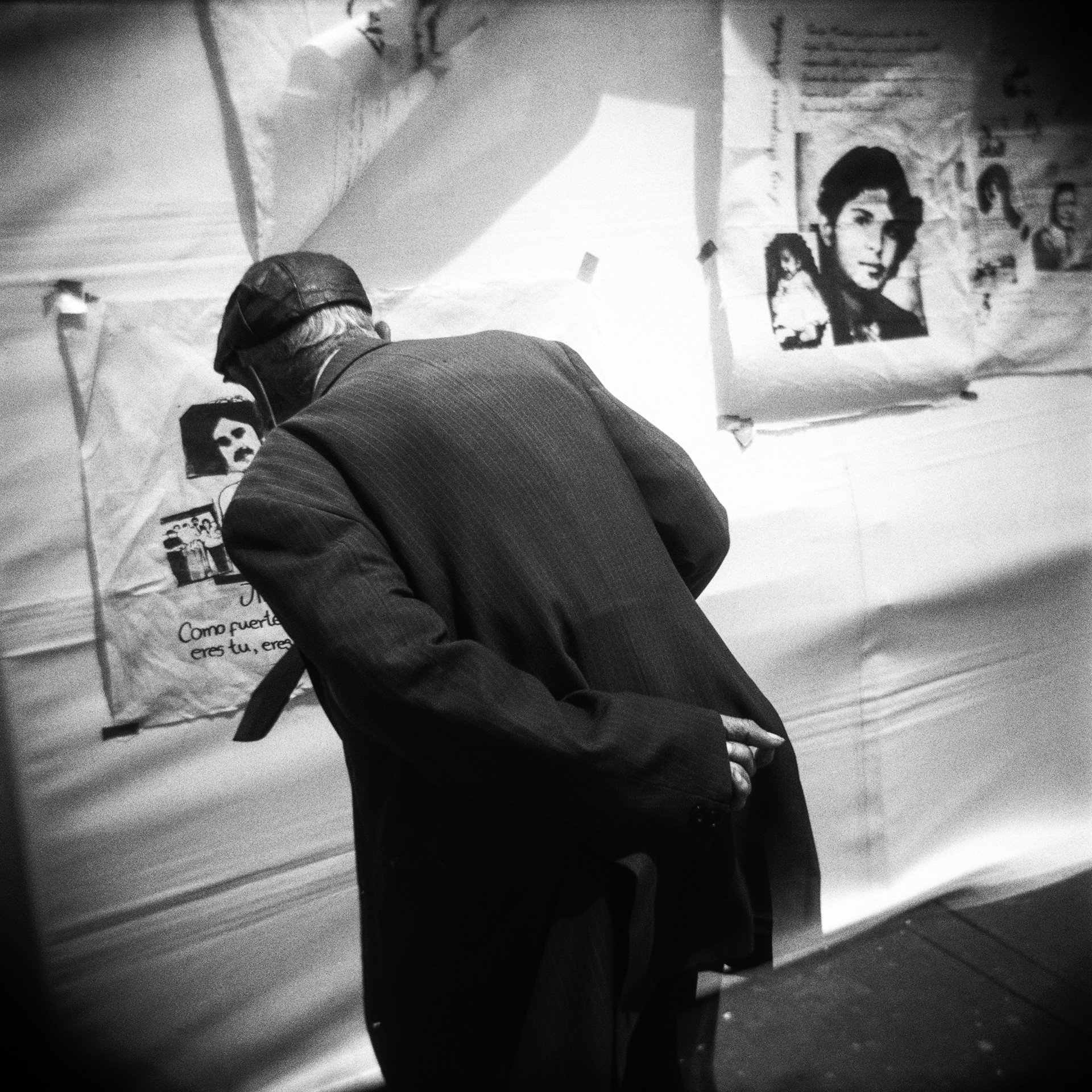 A passer-by looks at the photos of missing persons during a protest on the 36th anniversary of the siege of the Palace of Justice in Bogotá, Colombia. In November 1985, members of the 19th of April Movement (M-19) took over the Palace of Justice in Bogotá, taking hundreds of people hostage, including all 25 of the Supreme Court justices. Security forces stormed and retook the palace, in an operation that left up to 100 people dead, including many justices. Eleven survivors were taken away by security forces and never seen again.